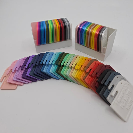 3D printed filament colour sample swatches in organised holders, showcasing a wide range of PLA Matte colours for 3D printing material selection spread out