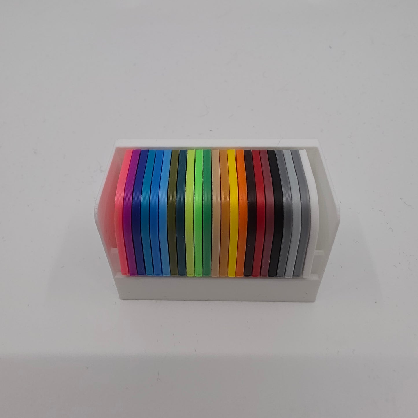3D printed filament colour sample swatches in organised holders, showcasing a wide range of PLA Pro colours for 3D printing material selection